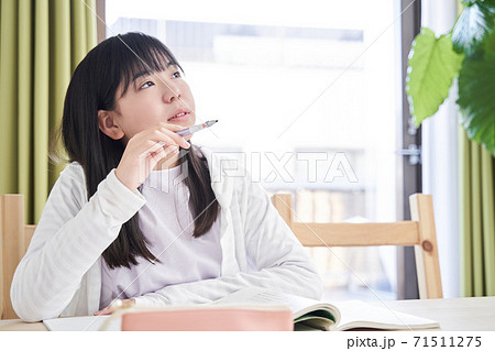 リビングで考え込む日本人女子中学生の写真素材