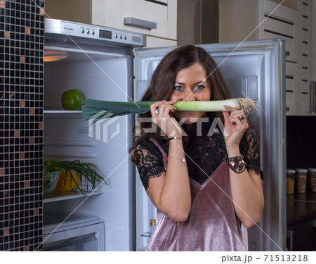 Woman in the dark at the open refrigerator 71513218