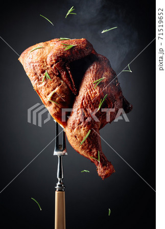 Smoked chicken on a fork sprinkled with rosemary. Smoked chicken on a fork sprinkled with rosemary. 71519652
