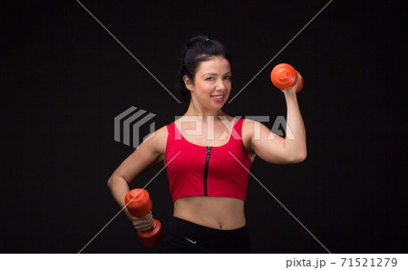 Brutal athletic woman pumping up muscules with dumbbells 71521279
