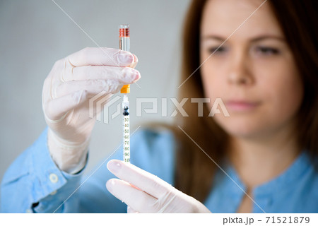 A girl fills a syringe for insulin injections. Diabetes. The short-acting insulin. Insulin injection at home. A girl fills a syringe for insulin injections. Diabetes. The short-acting insulin. Insulin injection at home. 71521879