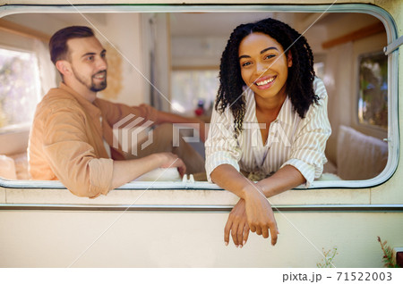 Couple looks out of rv window, camping in trailer Couple looks out of rv window, camping in trailer 71522003