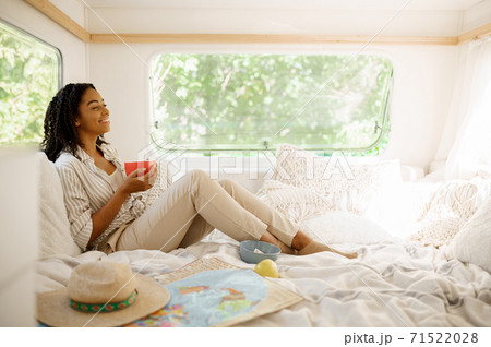Young woman relax in bed, camping in a trailer 71522028