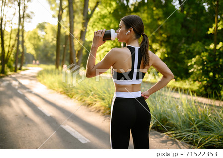 Morning training in park, woman drinks water Morning training in park, woman drinks water 71522353