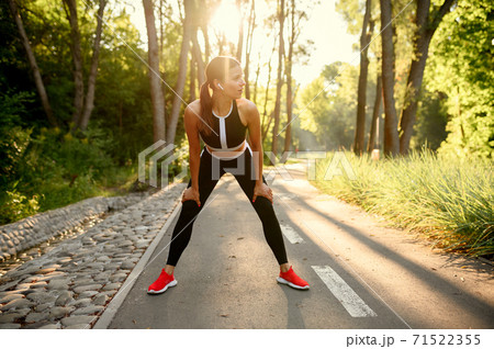 Morning training in park, woman in headphones 71522355