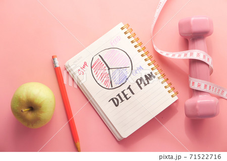 Diet plan with almond nut, dumbbells, apple on table 71522716
