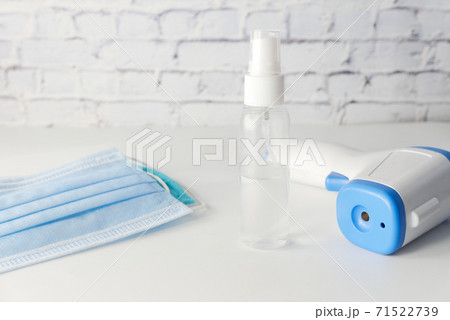 Surgical masks, thermometer and hand sanitizer on white background Surgical masks, thermometer and hand sanitizer on white background 71522739