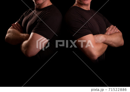 Men with strong hands. Male guards in a black T-shirt. Two men shoulder to shoulder. Men with strong hands. Male guards in a black T-shirt. Two men shoulder to shoulder. 71522886