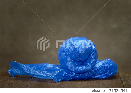 Rolled up new blue medical Shoe covers isolated on brown background. A pair of unrolled Shoe covers. 71524541
