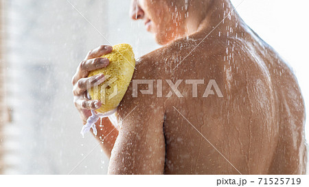 Young man washing his body with sponge 71525719