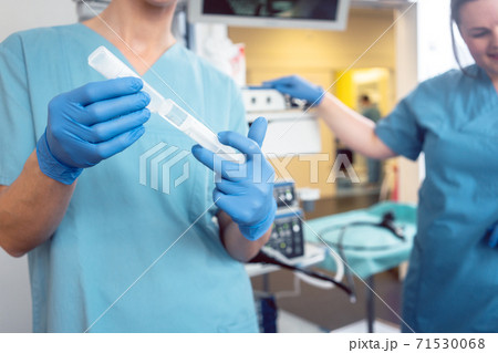 Nurse preparing anesthetic for surgery in hospital Nurse preparing anesthetic for surgery in hospital 71530068