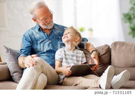 Grandfather and grandson using tablet on sofa Grandfather and grandson using tablet on sofa 71531105