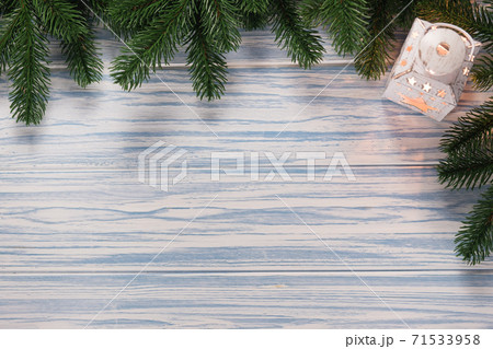 Christmas blue wooden background with fir branches and latern. Mockup for seasonal greetings. 71533958