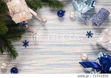Christmas blue wooden background with fir tree, gift boxes, latern and decorative sleigh. Christmas blue wooden background with fir tree, gift boxes, latern and decorative sleigh. 71533959