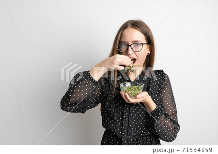 Caucasian young woman with salad isolated on white background. Microgreens superfood 71534159