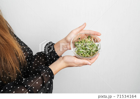 Caucasian young woman with salad isolated on white background. Microgreens superfood 71534164