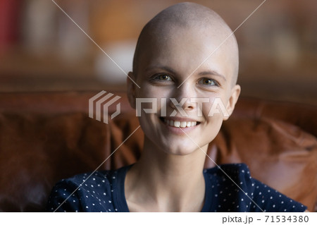 Optimistic female cancer patient sitting on couch looking at camera Optimistic female cancer patient sitting on couch looking at camera 71534380