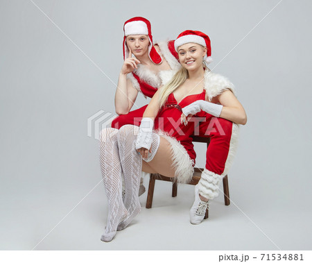 young guy and girl in Santa costumes. The concept of Christmas and the New year. photo session in the Studio on a white background 71534881