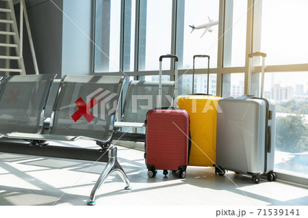 Traveling luggage in airport terminal and passenger plane flying over sky. 71539141