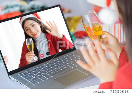 Two Asian women celebrating Christmas through computer screen 71539318