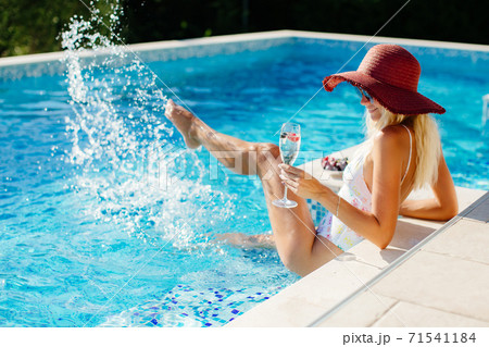 sexy woman relax in swimming pool and drinks champagne 71541184