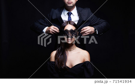 beautiful woman in mask and man in a suit beautiful woman in mask and man in a suit 71541934