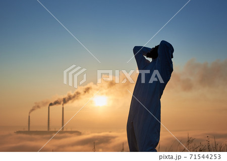 Male ecologist standing on territory of thermal power plant. 71544253