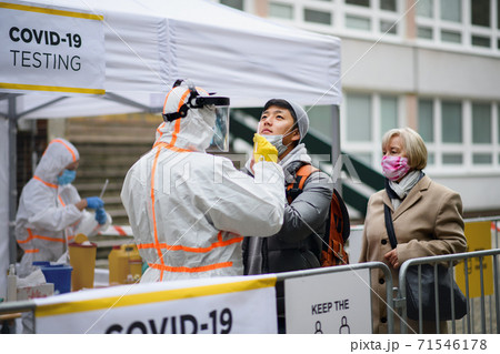 Young man in covid-19 testing center outdoors on street, coronavirus concept. 71546178