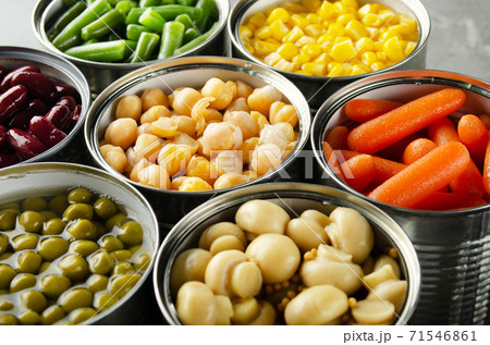 Canned vegetables in opened tin cans on kitchen table. Non-perishable long shelf life foods background Canned vegetables in opened tin cans on kitchen table. Non-perishable long shelf life foods background 71546861