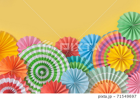 Colorful paper rosette and birthday garlands. Decorating for a party. Round, bright and color decoration. Yellow background. Colorful paper rosette and birthday garlands. Decorating for a party. Round, bright and color decoration. Yellow background. 71549697