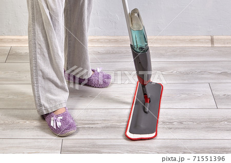 Cleaning room using mop with microfiber cloth and special liquid by house worker. Cleaning room using mop with microfiber cloth and special liquid by house worker. 71551396