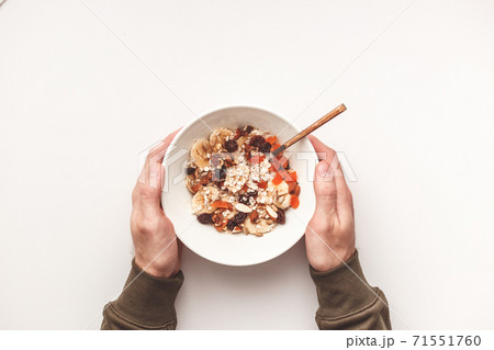 Carbohydrate healthy breakfast. Oatmeal with dried fruits on a white plate. View from above Carbohydrate healthy breakfast. Oatmeal with dried fruits on a white plate. View from above 71551760