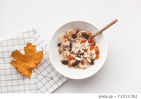Carbohydrate healthy breakfast. Oatmeal with dried fruits on a white plate. View from above Carbohydrate healthy breakfast. Oatmeal with dried fruits on a white plate. View from above 71551762