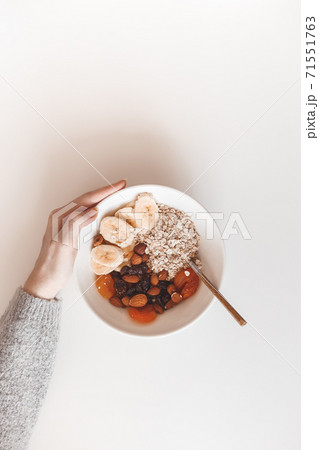 Carbohydrate healthy breakfast. Oatmeal with dried fruits on a white plate. View from above 71551763