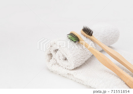 Wooden toothbrushes on white towel with copy space. Ecological material and dental care 71551854