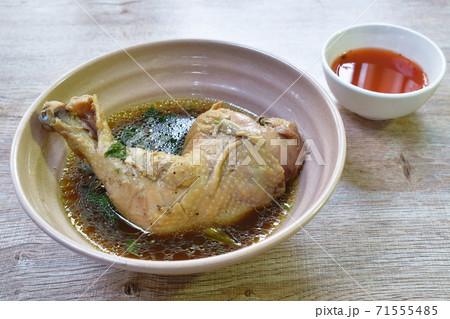 boiled chicken thigh and leg with herb brown soup in bowl dipping spicy chili sauce cup boiled chicken thigh and leg with herb brown soup in bowl dipping spicy chili sauce cup 71555485