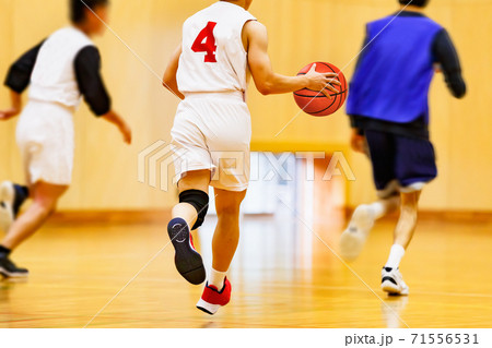 体育館でバスケットボールをする学生 71556531