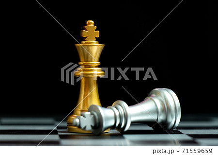 Gold king chess piece win over lying down silver king on black background Gold king chess piece win over lying down silver king on black background 71559659