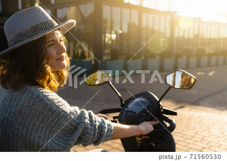 Woman riding an electric scooter Woman riding an electric scooter 71560530