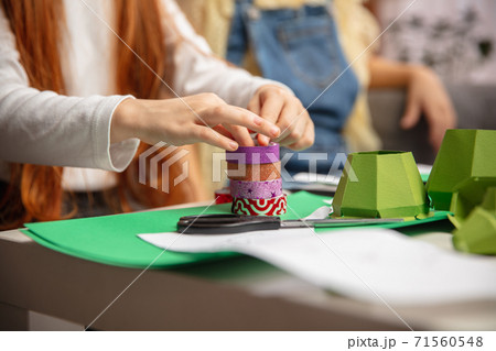 Close up hands of two little children, girls together in creativity of the house. Kids make handmade toys for games or New Year celebration 71560548