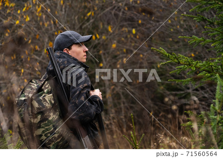 Hunter with a gun and a backpack Hunter with a gun and a backpack 71560564