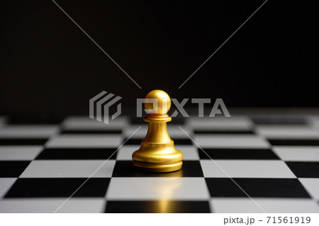 Chess piece pawn on a board on a dark background Chess piece pawn on a board on a dark background 71561919