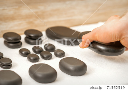 Masseur lays out massage stones 71562519