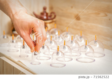 Masseur takes vacuum massage jars 71562522