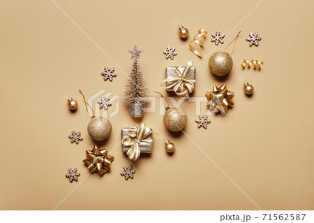 Golden christmas decor and bauble on beige background. Creative layout in neutral monochrome colors 71562587