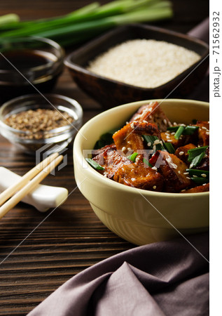 Crispy stir fried tofu cubes with chives in clay dish  71562932