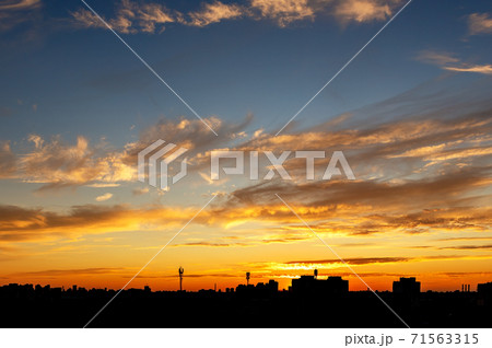 Dramatic colorful red purple to blue sunset or sunrise sky landscape with line row of city buildings silhouette . Natural beautiful cityscape dawn background wallpaper. Metropolis rise twilight time 71563315