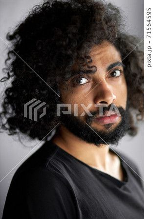 close-up portrait of handsome calm arab man in black shirt posing in studio 71564595