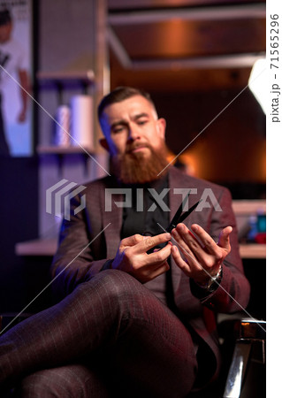 close-up photo of scissors in hands of professional male barber 71565296