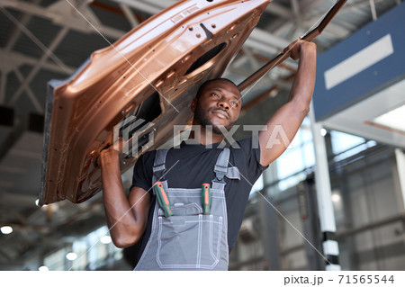 afro american auto mechanic is going to change seperate part of automobile 71565544